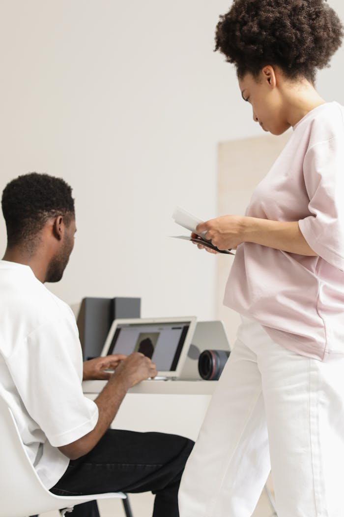 about-us Two professionals working together in a modern office setting with technology and teamwork evident.